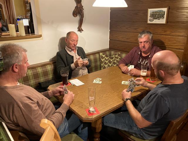 eine Gruppe von Männern, die um einen Tisch mit Getränken sitzen